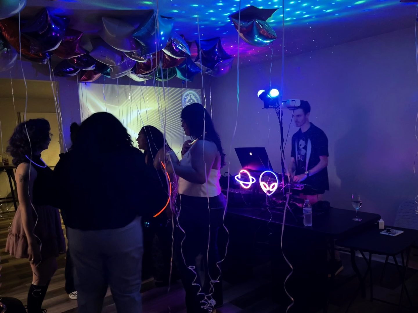 Guests enjoying music beside the booth in a small party space