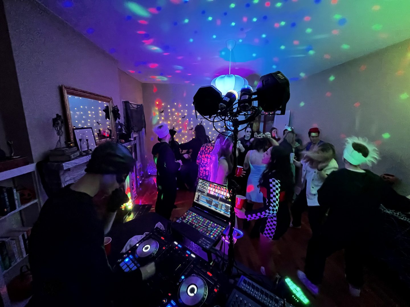 A view across the dance floor with guests and colorful ceiling lights